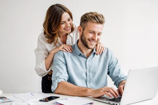 Engaging couple sharing a productive moment while working on a laptop in a modern indoor workspace photo