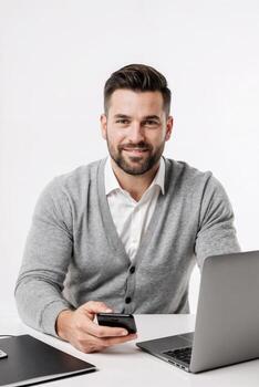 A man in a sweater is holding a cell phone and smiling photo