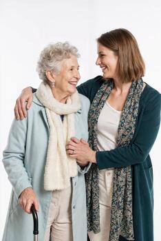 Two women share a joyful moment while embracing each other in a bright, neutral setting during a family gathering photo