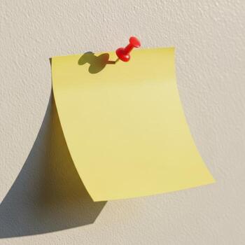 Yellow sticky note pinned to a light colored surface with shadow photo