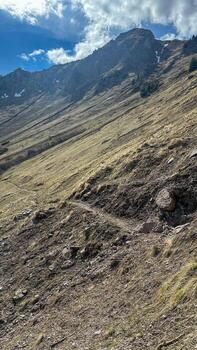View of an alpine mountain range with remnants of snow against the sky on a spring day photo
