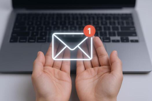 Unread Email Notification Concept Hands Holding Glowing Email Icon Above Laptop Keyboard photo