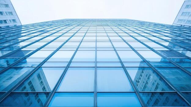 Modern Skyscraper Facade with Blue Glass Windows Reflecting Sky, Emphasizing Height and Architectural Design photo