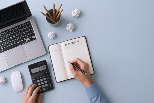 Overhead View of Accounting Workspace with Laptop, Calculator, and Notebook on Pastel Blue Background photo