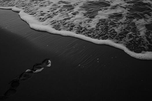 Footprints in the sand with waves gently rolling in at sunset photo