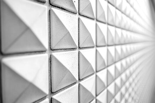 Textured wall featuring geometric triangular patterns in grayscale tones photo