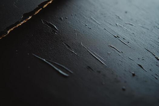 Textured black surface with scratches and traces of liquid in daylight photo