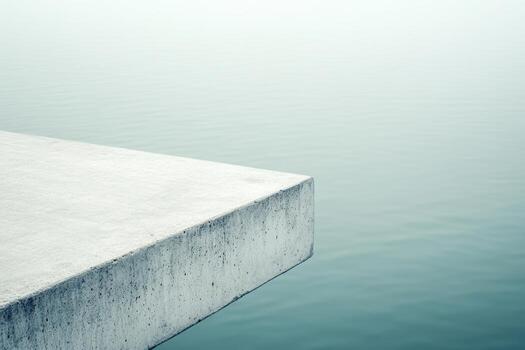 Calm waterfront view with concrete pier extending over still water photo