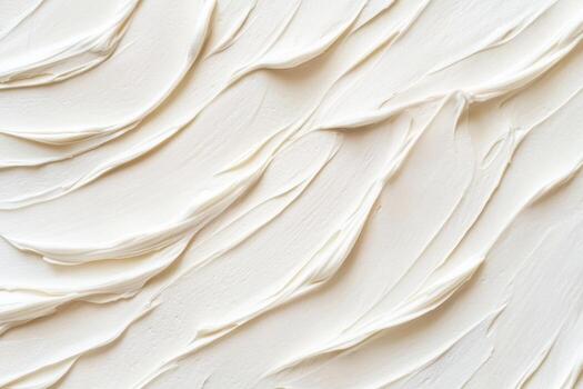 Creamy texture of white paint spread on a canvas in abstract swirls photo