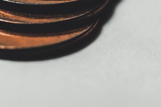 Stacked copper coins creating an abstract pattern on a white surface photo
