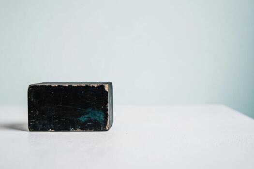 Solid black rectangular object on a white surface in a minimalist setting photo