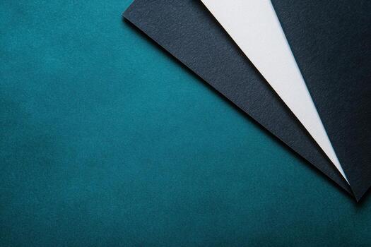 Layers of cardstock on a teal background for creative projects and crafts photo