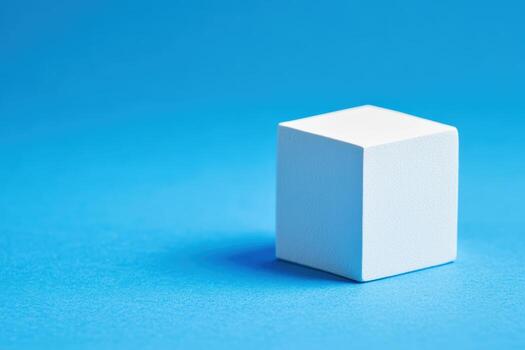 White geometric cube resting on a vibrant blue background photo
