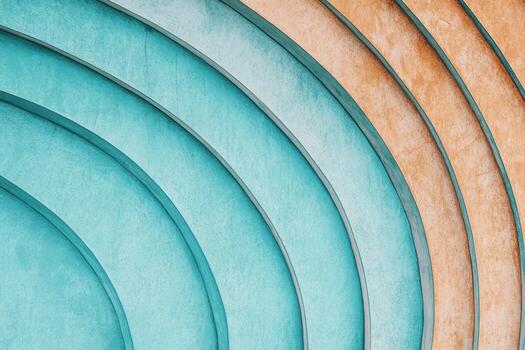 Curved architectural patterns with turquoise and orange hues in urban setting photo