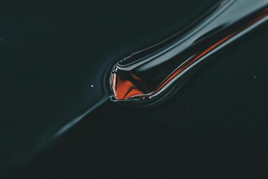 Fluid red substance flowing smoothly on a dark surface photo