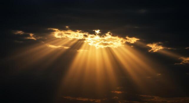 Golden sun rays breaking through dark clouds creating a dramatic and hopeful sky scene photo
