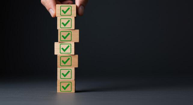 Hand stacking wooden blocks with green check marks, illustrating task completion and success photo