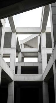 Low angle view of a concrete structure with repeating square and rectangular shapes against a bright sky photo