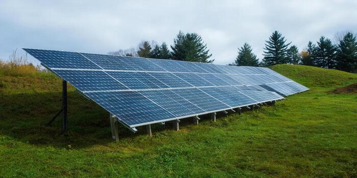 A solar panel array on a green hill, harnessing the power of the sun for clean energy. photo