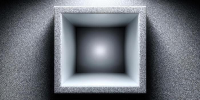 An empty square niche in a gray textured wall, illuminated with dramatic lighting and shadows. photo
