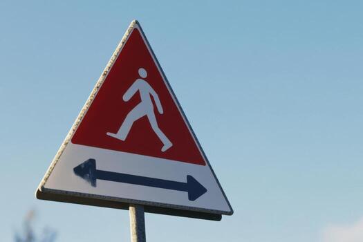 A pedestrian sign with a man walking on it photo