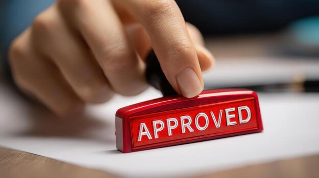 Close Up of Hand Stamping Approved on Document, Symbolizing Agreement and Authorization photo