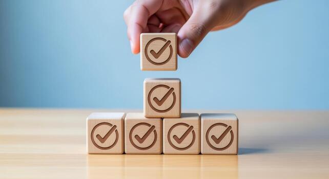 Hand Arranging Wooden Blocks with Checkmark Symbols, representing Goals Achievement and Business Success photo