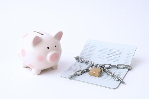 Savings Secured Piggy Bank with Chain and Lock Protecting Bankbook on White Background photo