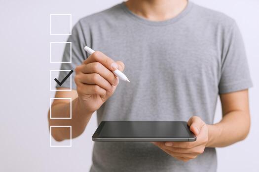 Man Holding Tablet Completes Digital Checklist, Marking Approval with Pen in Business Workflow photo