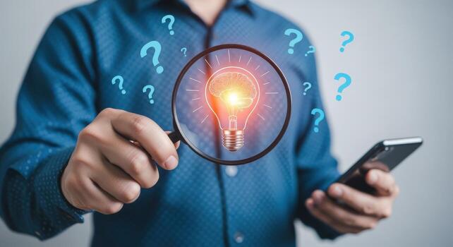 Conceptual idea creation process Man holding magnifying glass over a lightbulb representing innovation photo