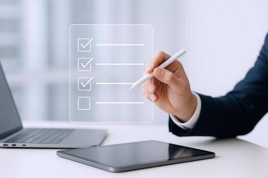 Business Professional Completing Digital Checklist on Transparent Screen with Stylus, Laptop and Tablet on Desk photo