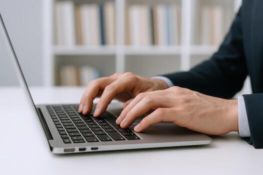 Close-up of executive typing on laptop keyboard in modern office environment for business communication photo