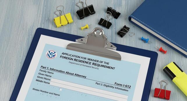 I-612 Form Application Waiver of Foreign Residence Requirement on a Clipboard with Office Supplies photo