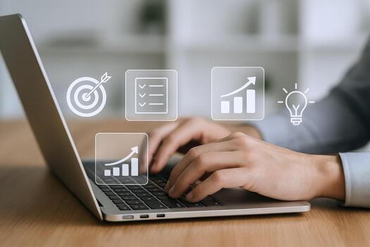 Business professional using laptop with icons representing goal, strategy, checklist and performance analytics photo