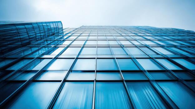 Modern Office Building Facade with Glass Windows Reflecting Sky in Upward Perspective photo