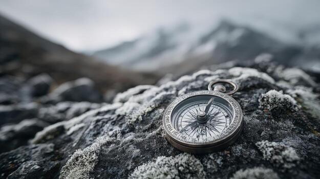 Compass on Rocky Terrain Navigating the Snowy Mountain Landscape for Exploration and Adventure photo
