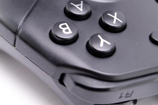 Close-up of a Black Game Controller with A B X Y Buttons on White Background. photo