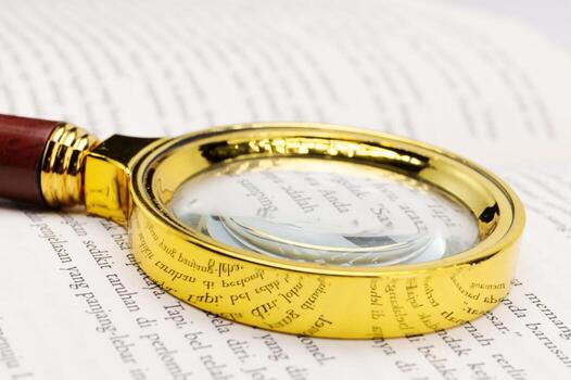 dorado aumentador vaso en texto - de cerca ver de leyendo y investigación herramienta. foto