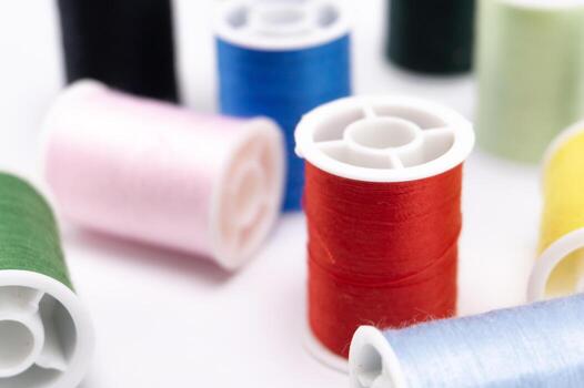 Colorful Thread Spools - Red Blue Pink Green Black and Yellow on White Background Sewing Supplies. photo