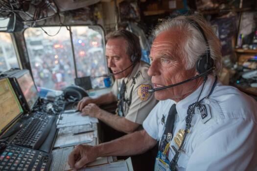 Two men in uniform sitting at a desk with headsets photo