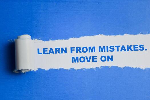 Learn from mistakes. Move on Text written in torn paper photo