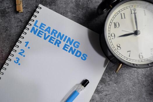 Concept of Learning never ends write on book Supported by an additional services isolated on Wooden Table. photo