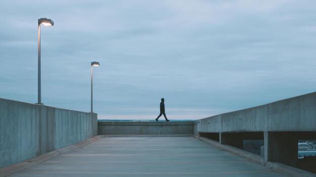 Person Walking on Edge of Building at Dusk for Urban Exploration and Individuality Concepts photo
