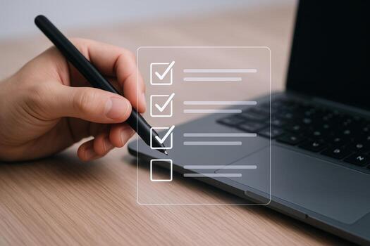 Completing Digital Checklist on Laptop Business Professional Marking Tasks with Stylus for Project Management photo