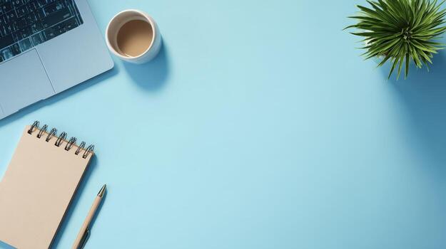 Workspace Flat Lay with Laptop, Notepad, Coffee, and Plant on a Clean Blue Background photo