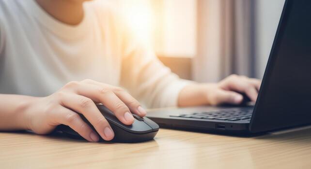 Person Using Laptop and Mouse for Online Work or Study in Bright, Modern Workspace photo