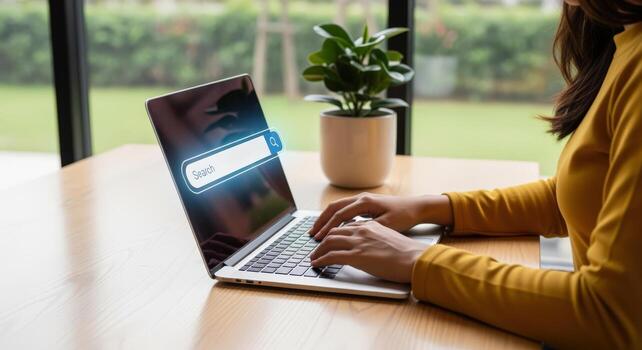 Woman Typing on Laptop with Search Bar Overlay for Online Content Consumption and Information Access photo