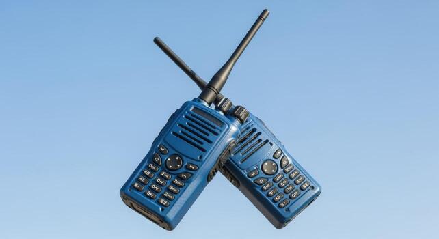 Two Blue Walkie Talkies Interlocked Against a Clear Sky Background Representing Communication and Coordination photo