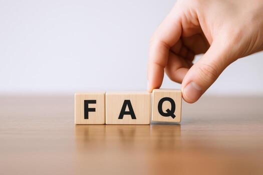 Frequently Asked Questions Concept Hand Arranging Blocks Spelling FAQ on Wooden Table Against White Background photo