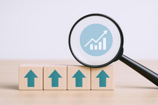 Growth Analysis Concept Magnifying Glass Examining Upward Arrows on Wooden Blocks Illustrating Progress and Business Development photo